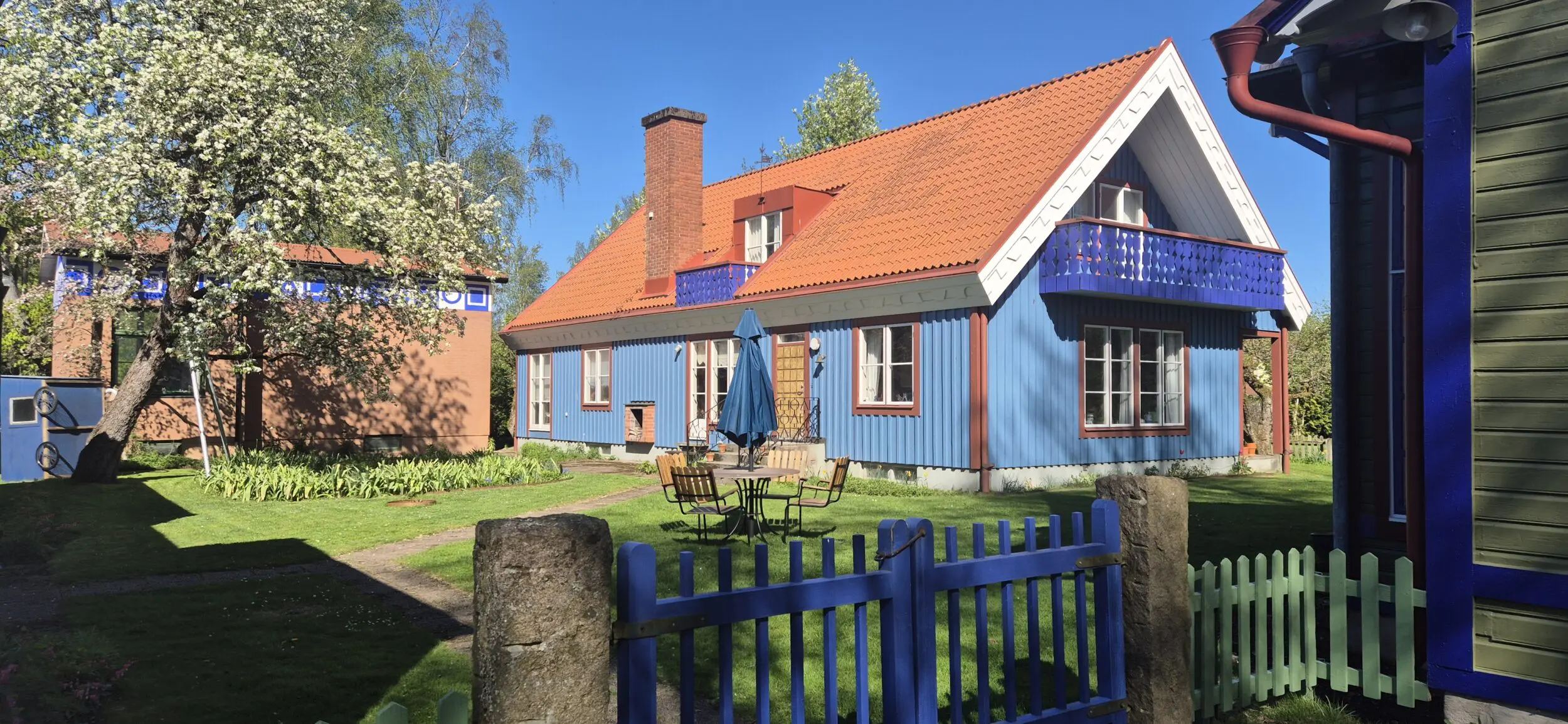 Blått trähus med rött tegeltak